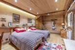 Experience rustic charm in this cozy bedroom, featuring warm wooden walls and ceilings.
