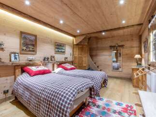 Experience rustic charm in this cozy bedroom, featuring warm wooden walls and ceilings.