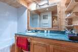 This charming bathroom features a rustic wooden vanity with a marble countertop, offering a touch of elegance.