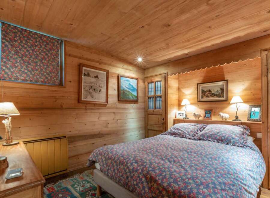 This cozy bedroom features a warm, inviting atmosphere with its wooden walls and ceiling.