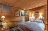 This cozy bedroom features a warm, inviting atmosphere with its wooden walls and ceiling.