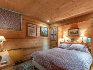 This cozy bedroom features a warm, inviting atmosphere with its wooden walls and ceiling.