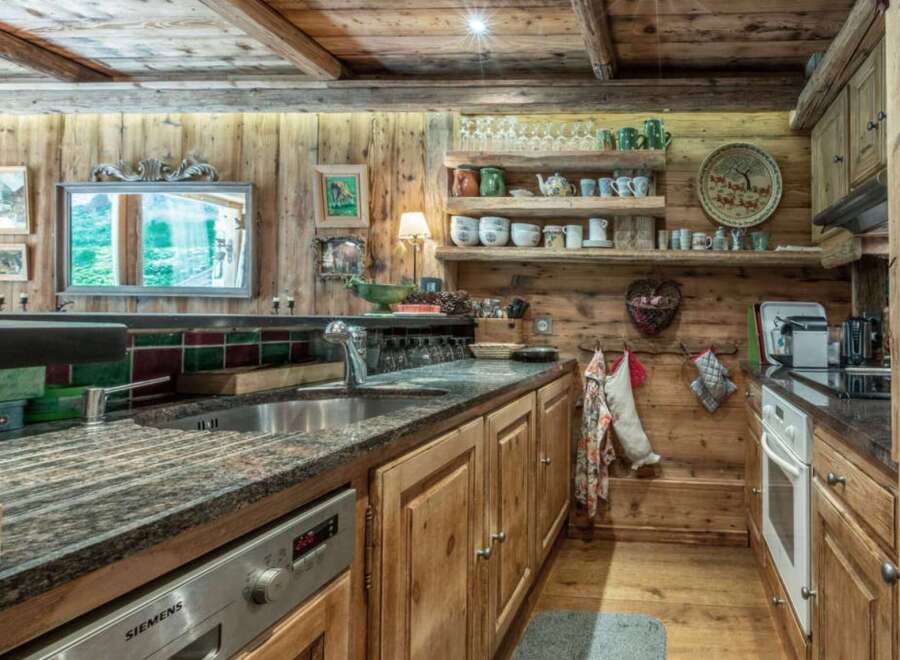 This rustic kitchen exudes warmth and charm with its wooden cabinetry and exposed beams.