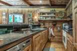 This rustic kitchen exudes warmth and charm with its wooden cabinetry and exposed beams.
