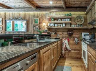 This rustic kitchen exudes warmth and charm with its wooden cabinetry and exposed beams.