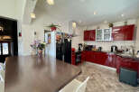 This stunning kitchen boasts modern design with sleek red cabinetry and stainless steel appliances.