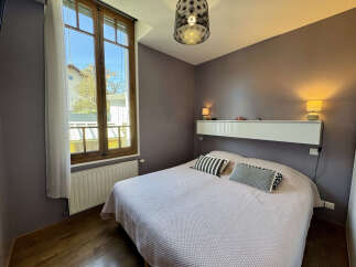 This cozy bedroom features a comfortable bed with stylish pillows, perfect for a relaxing retreat.