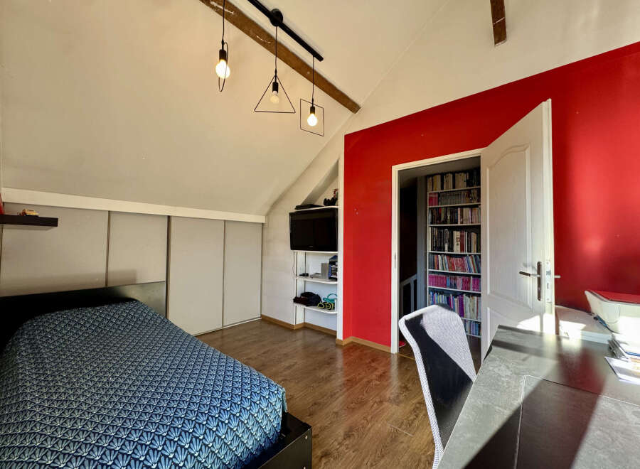 Discover this charming bedroom featuring a modern design with a pop of red accent wall.