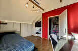 Discover this charming bedroom featuring a modern design with a pop of red accent wall.