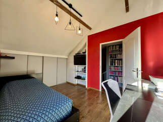 Discover this charming bedroom featuring a modern design with a pop of red accent wall.