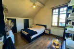 This cozy bedroom features a comfortable bed with a stylish navy blue throw blanket, perfect for relaxing.