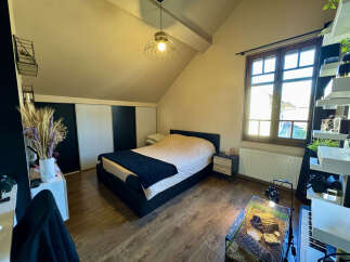 This cozy bedroom features a comfortable bed with a stylish navy blue throw blanket, perfect for relaxing.