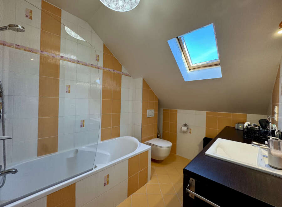 Discover the charm of this unique bathroom! Featuring a skylight that floods the space with natural light, this bathroom offers a bright and airy feel.