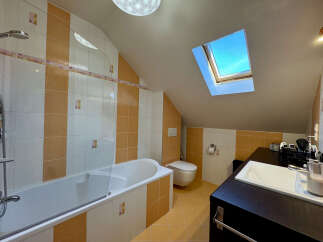 Discover the charm of this unique bathroom! Featuring a skylight that floods the space with natural light, this bathroom offers a bright and airy feel.