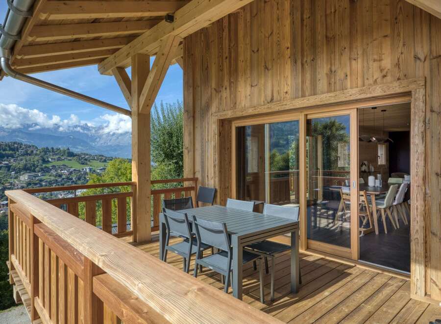 Experience luxury living with this stunning property featuring a spacious wooden deck and breathtaking mountain views.