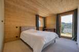 This cozy bedroom features stunning wooden paneling on the walls and ceiling, creating a warm and inviting atmosphere.
