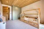 This charming bedroom features a cozy wooden bed frame and a spacious wardrobe, perfect for a child's sanctuary.