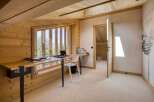 This stunning home office features a unique design with natural wood finishes and ample natural light.