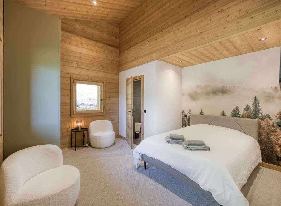 This cozy bedroom features a stunning wooden ceiling and walls, creating a warm and inviting atmosphere.