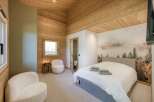 This cozy bedroom features a stunning wooden ceiling and walls, creating a warm and inviting atmosphere.