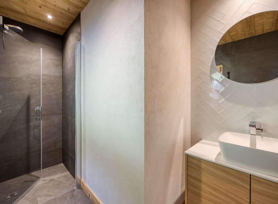 Step into a modern bathroom retreat, showcasing a sleek glass-enclosed shower and a stylish vanity area.