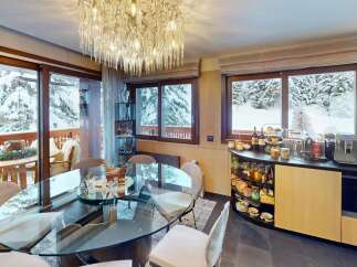 Experience the epitome of luxury living in this stunning property, featuring a sophisticated dining area with a breathtaking view of snow-covered landscapes.