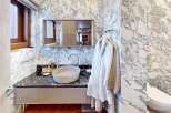 Experience luxury in this stunning bathroom featuring exquisite marble walls and a sleek, modern design.