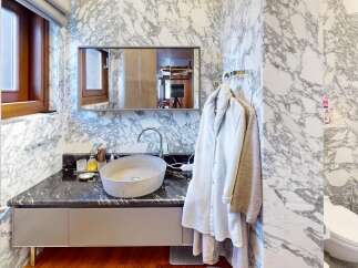 Experience luxury in this stunning bathroom featuring exquisite marble walls and a sleek, modern design.