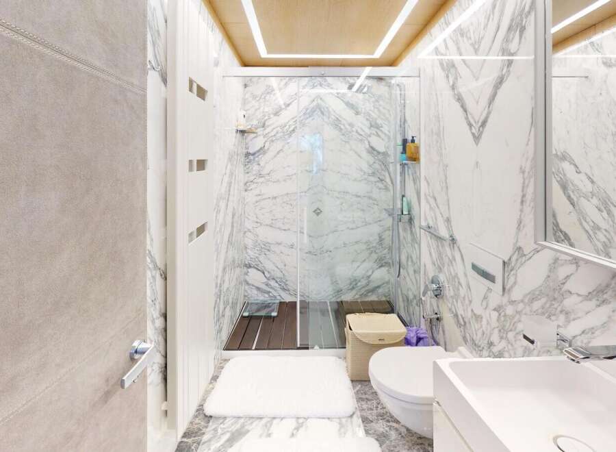 Step into luxury with this stunning bathroom, featuring exquisite marble accents and a modern design.