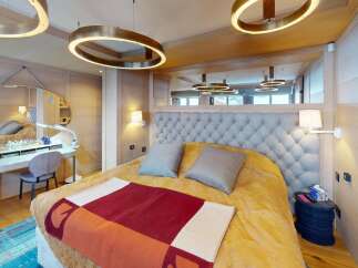 Experience luxury in this stunning bedroom, featuring a plush tufted headboard and elegant lighting fixtures.