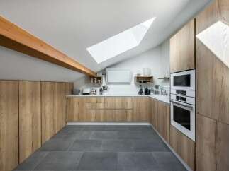 This stunning kitchen boasts a modern design with sleek wooden cabinetry, offering ample storage and a warm, inviting atmosphere.