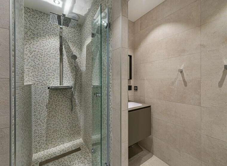 Step into a modern bathroom oasis! This stunning space features a sleek glass-enclosed shower with a rainfall showerhead, complemented by stylish tile work.