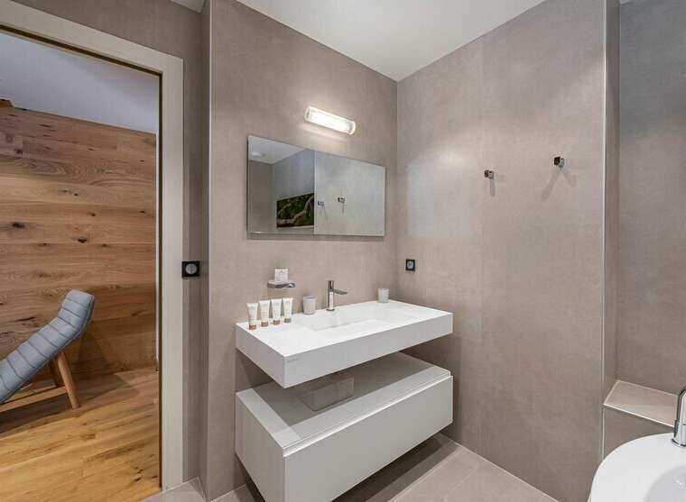 This modern bathroom features a sleek, floating vanity with ample storage and a minimalist design.