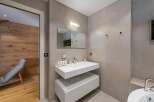 This modern bathroom features a sleek, floating vanity with ample storage and a minimalist design.