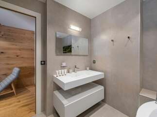 This modern bathroom features a sleek, floating vanity with ample storage and a minimalist design.
