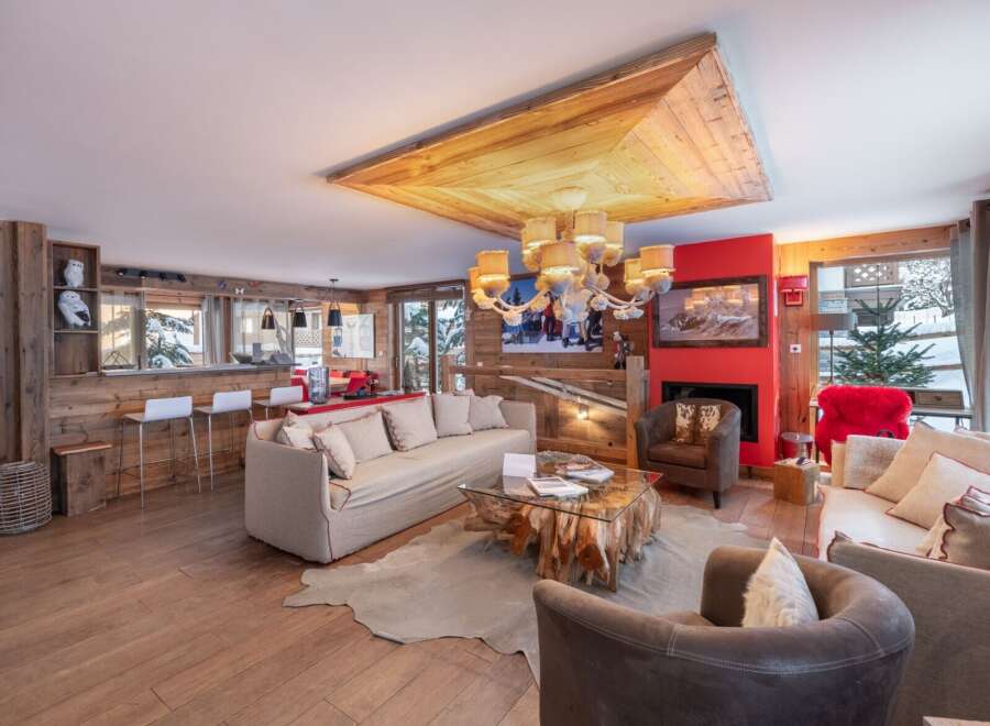 Experience luxury living in this stunning chalet, featuring a cozy fireplace and a unique wooden ceiling design.