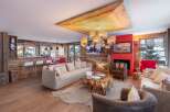 Experience luxury living in this stunning chalet, featuring a cozy fireplace and a unique wooden ceiling design.
