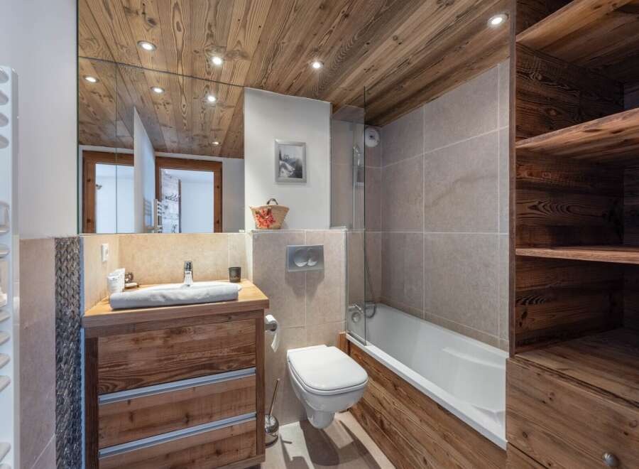 This stunning bathroom boasts a rustic charm with its wooden ceiling, vanity, and accents.