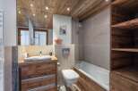 This stunning bathroom boasts a rustic charm with its wooden ceiling, vanity, and accents.