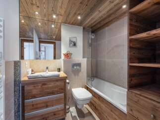 This stunning bathroom boasts a rustic charm with its wooden ceiling, vanity, and accents.