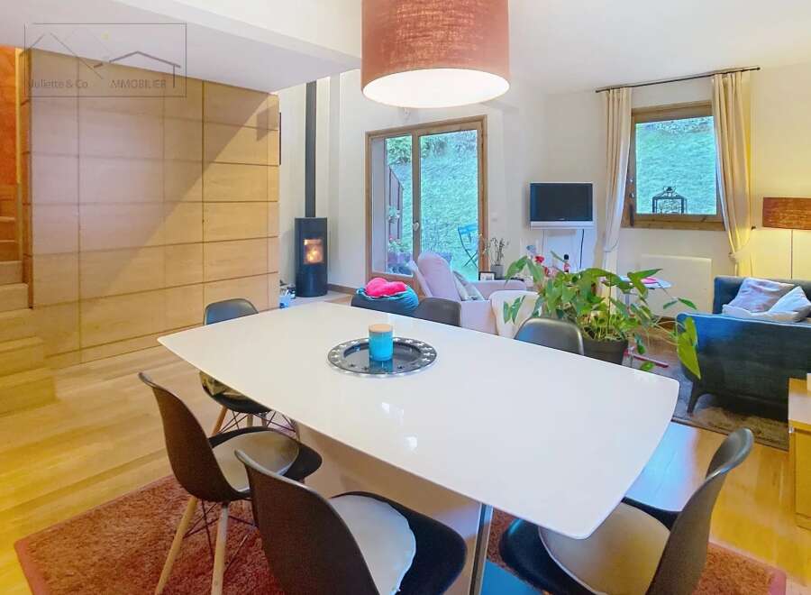 Discover this stunning property featuring a modern dining area with a sleek white table and stylish chairs.