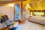 Discover the charm of this cozy bedroom, featuring a unique wooden ceiling and a comfortable bed.