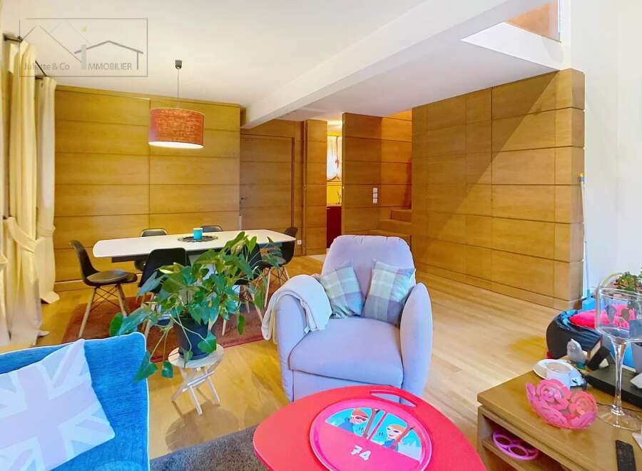 Discover this stunning property featuring a modern living space with a cozy armchair and a vibrant red coffee table.