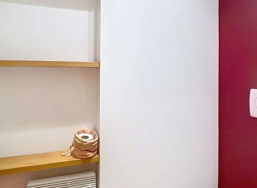 Discover this stylish bathroom featuring a modern design and practical shelving.