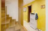Step into this inviting entryway, showcasing a beautiful wooden staircase and a bright, yellow-painted hallway.