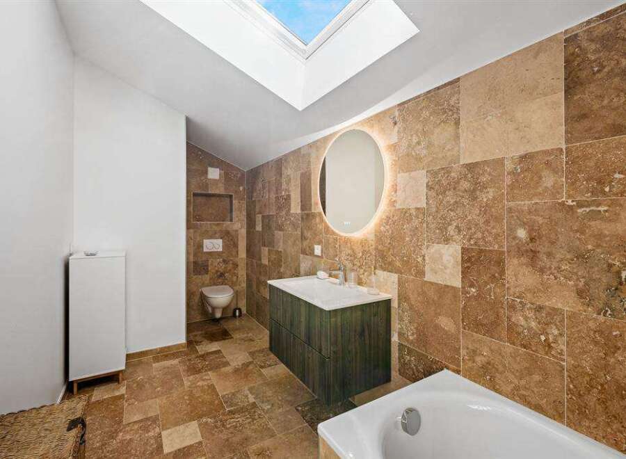This stunning bathroom boasts a luxurious design with natural stone tiles and a modern vanity.