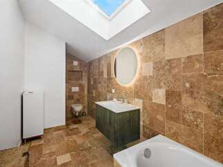 This stunning bathroom boasts a luxurious design with natural stone tiles and a modern vanity.