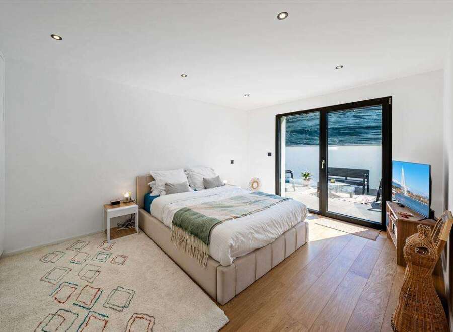 This modern bedroom offers a serene retreat with its minimalist design and ample natural light.