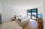 This modern bedroom offers a serene retreat with its minimalist design and ample natural light.