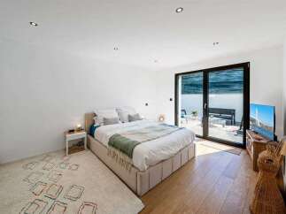 This modern bedroom offers a serene retreat with its minimalist design and ample natural light.
